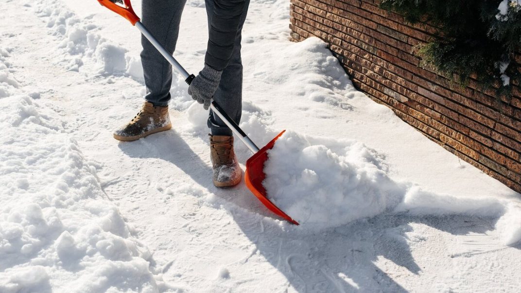 A person clearing snow with a shovel.