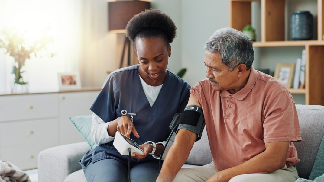 Blood pressure targets: Should we go higher or lower? 1 Elderly man getting blood pressure measured by a healthcare professional in his home.