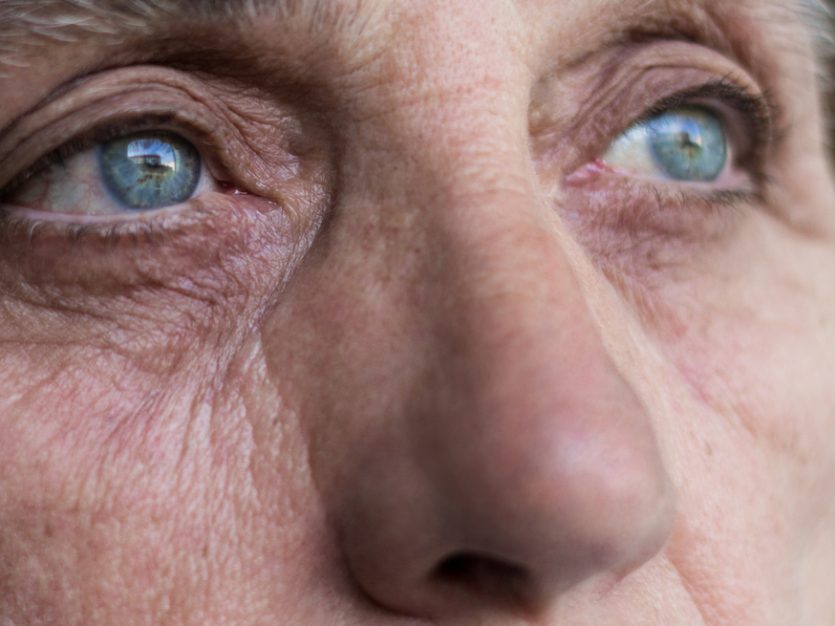 Close up of a senior woman's face and eyes looking off into the distance.