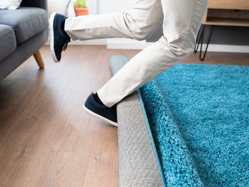 Legs tripping over a rug in a living room.