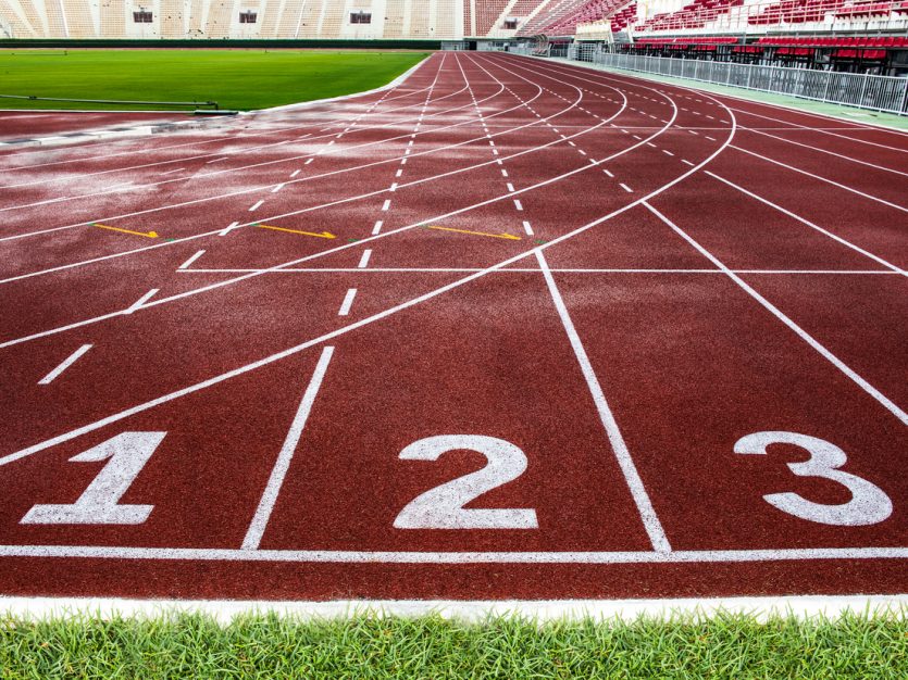 Starting line of red running track in a large stadium.