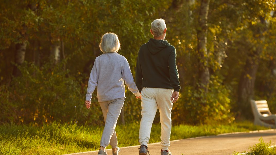 A Breath of Fresh Air: How Getting Outside This Spring Can Brighten Your Parent’s Day 1 Married Senior Couple Walking Together On A Sunny Summer Evening.
