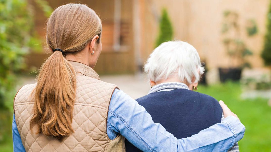 caregiver and seniors walking outside