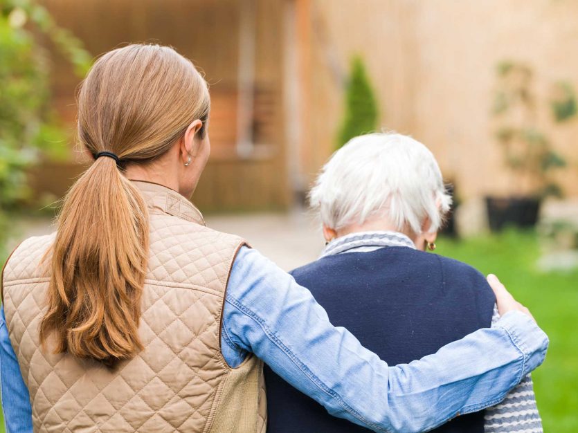 caregiver and seniors walking outside