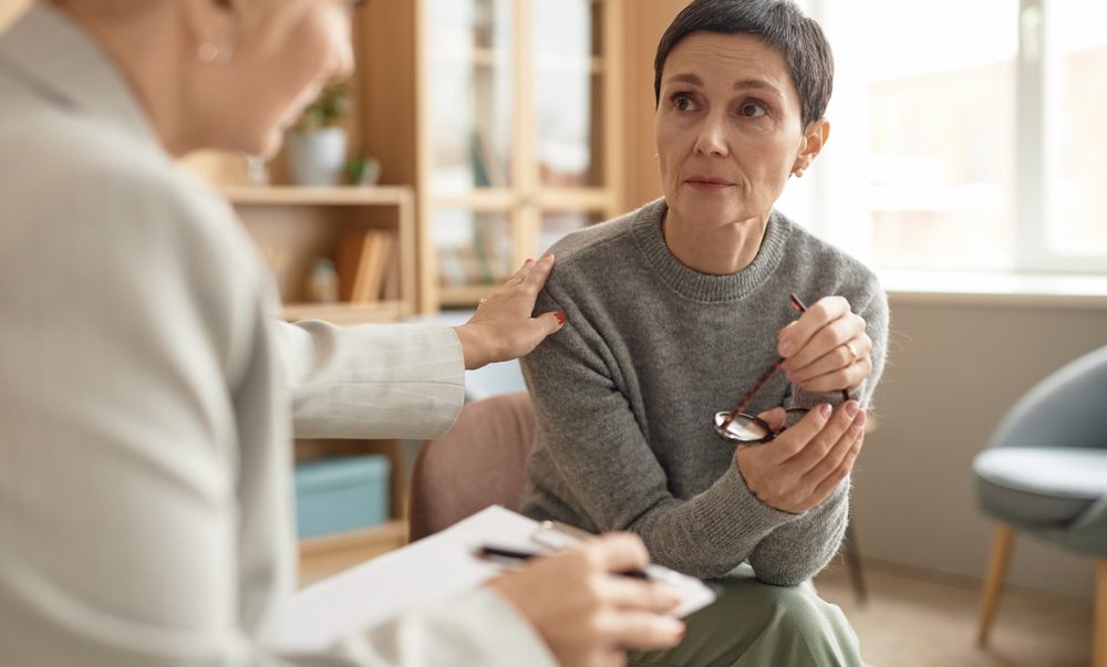A woman holding glasses and looking at another woman