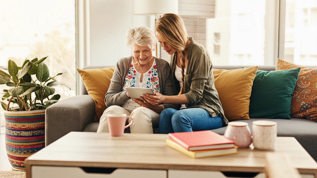 A young woman helping a senior with ways to avoid scams - protecting seniors from scams