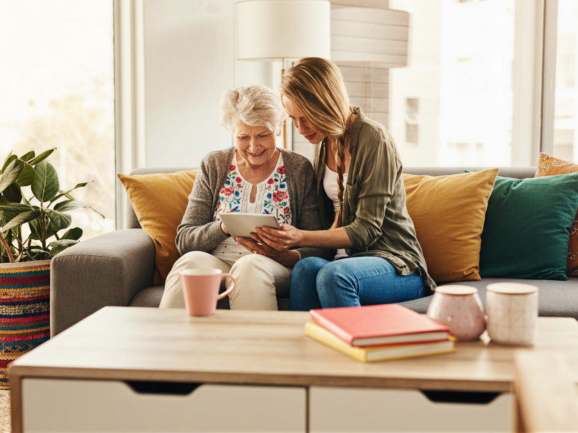 A young woman helping a senior with ways to avoid scams - protecting seniors from scams