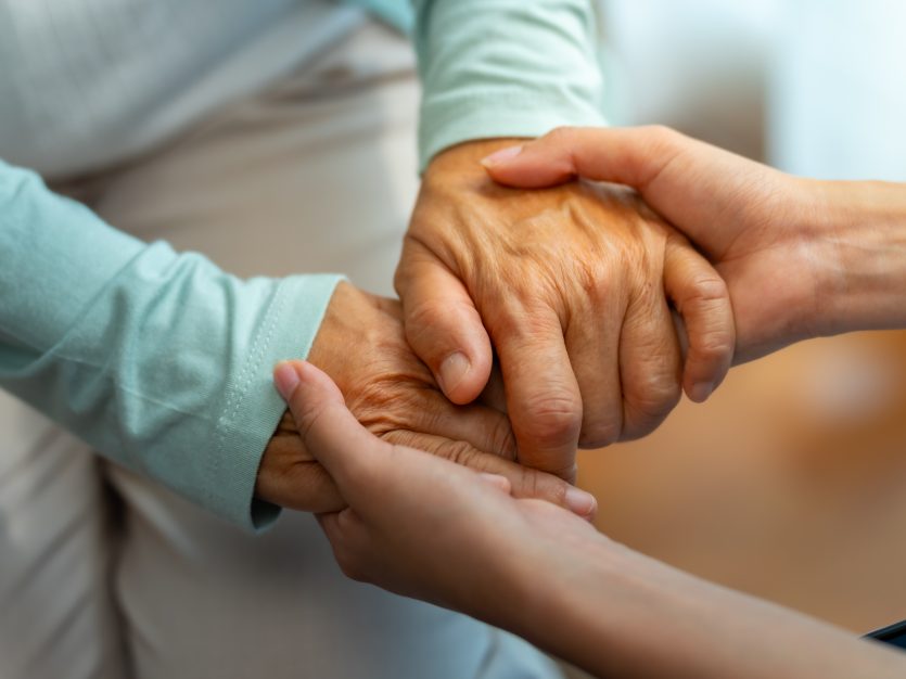 Alzheimer's care - Two hands holding each other gently.