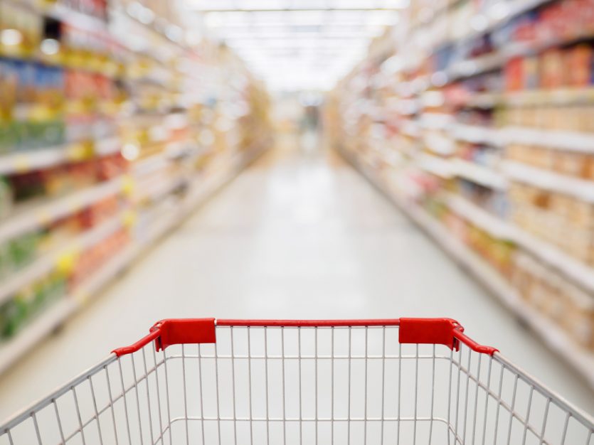 Shopping cart view in Supermarket aisle with product shelves abstract blur defocused background